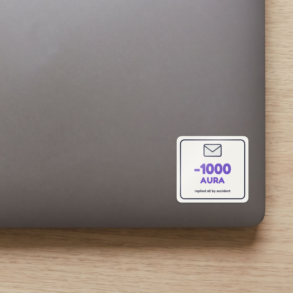 -1000 Aura: Replied All sticker on the lid of a grey laptop