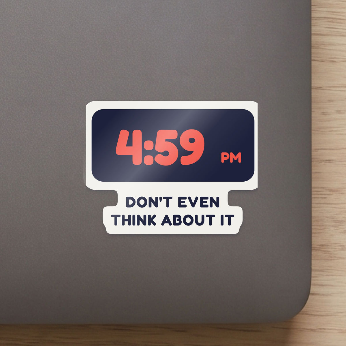 4:59 PM sticker on the lid of a grey laptop