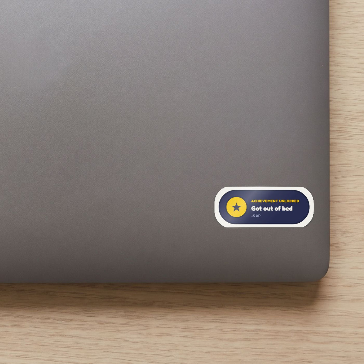 Achievement Unlocked: Got Out of Bed sticker on the lid of a grey laptop