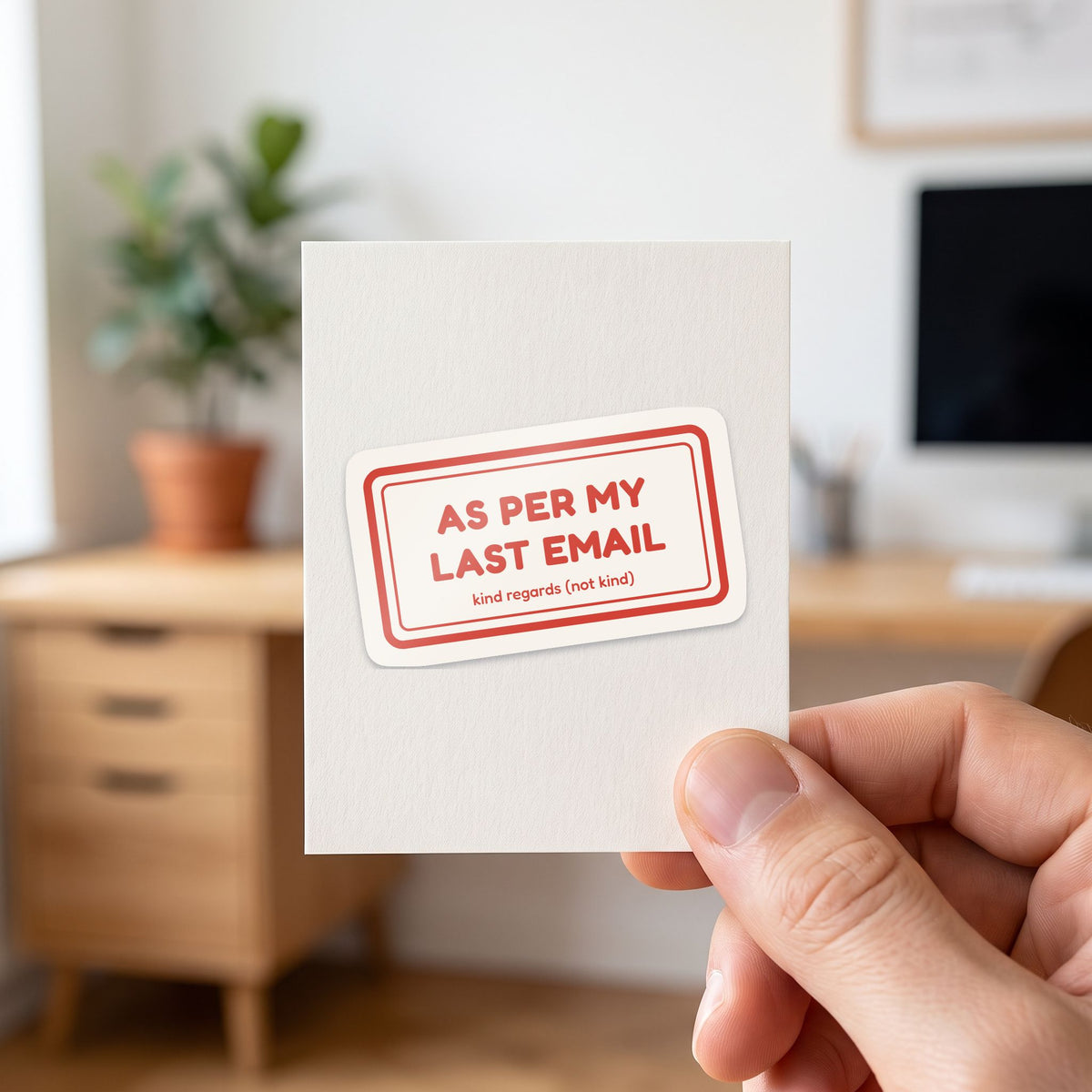 As Per My Last Email sticker held in a hand on its white backing card
