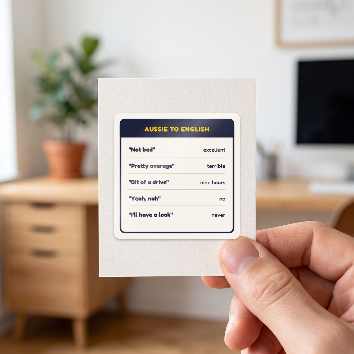 Aussie to English sticker held in a hand on its white backing card