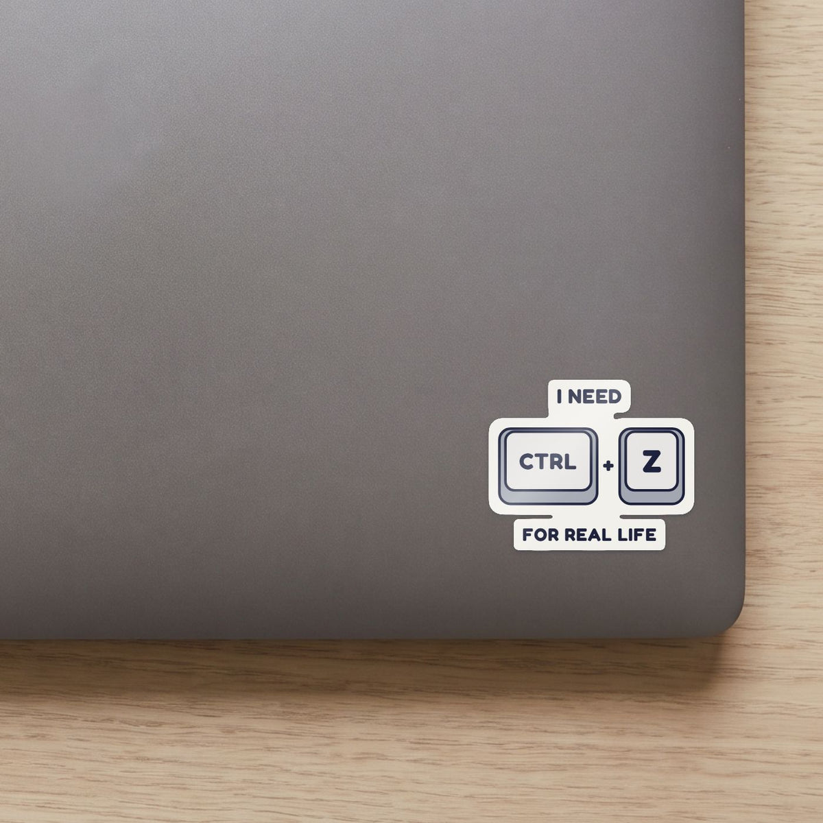 Ctrl + Z sticker on the lid of a grey laptop