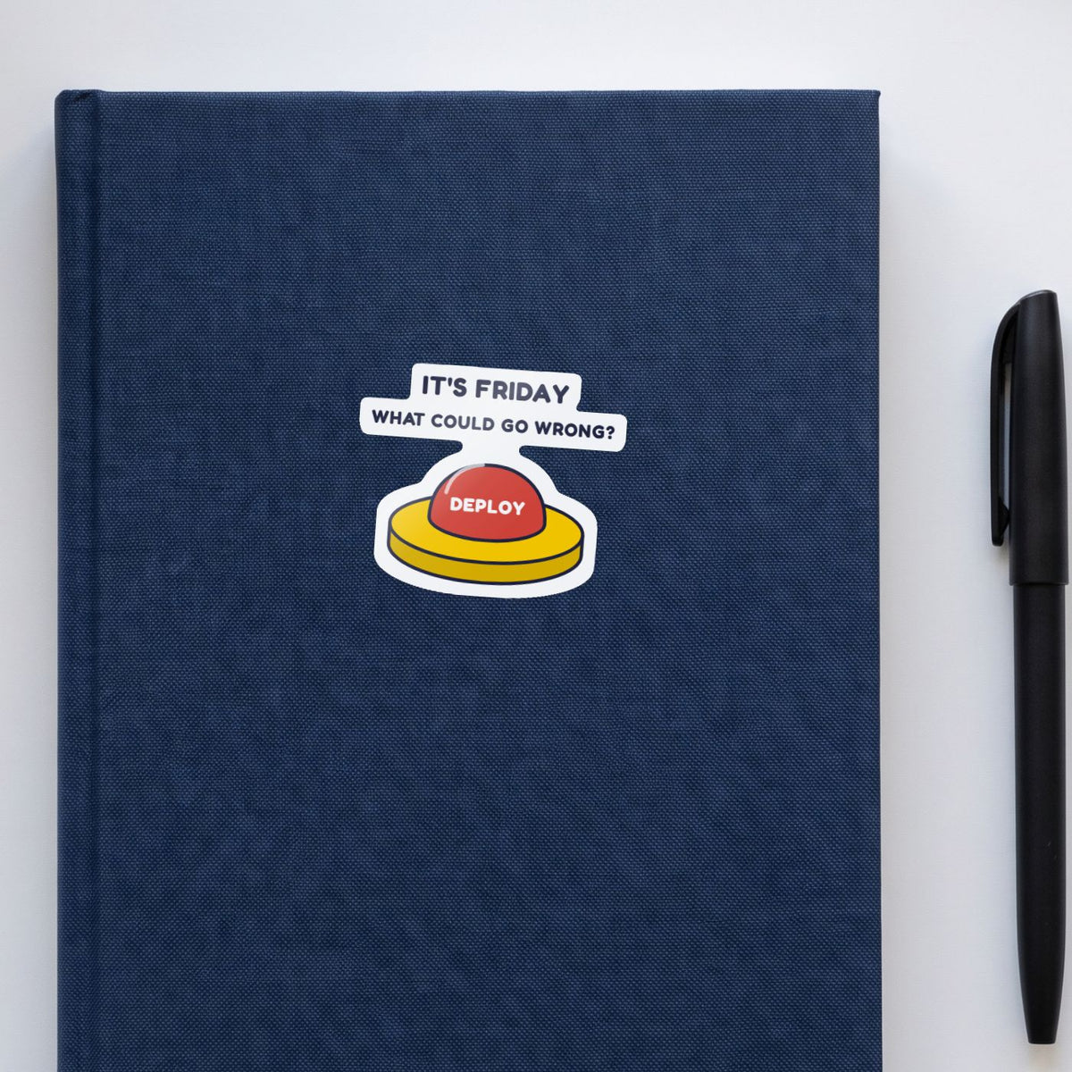 Deploy on Friday sticker on a navy notebook