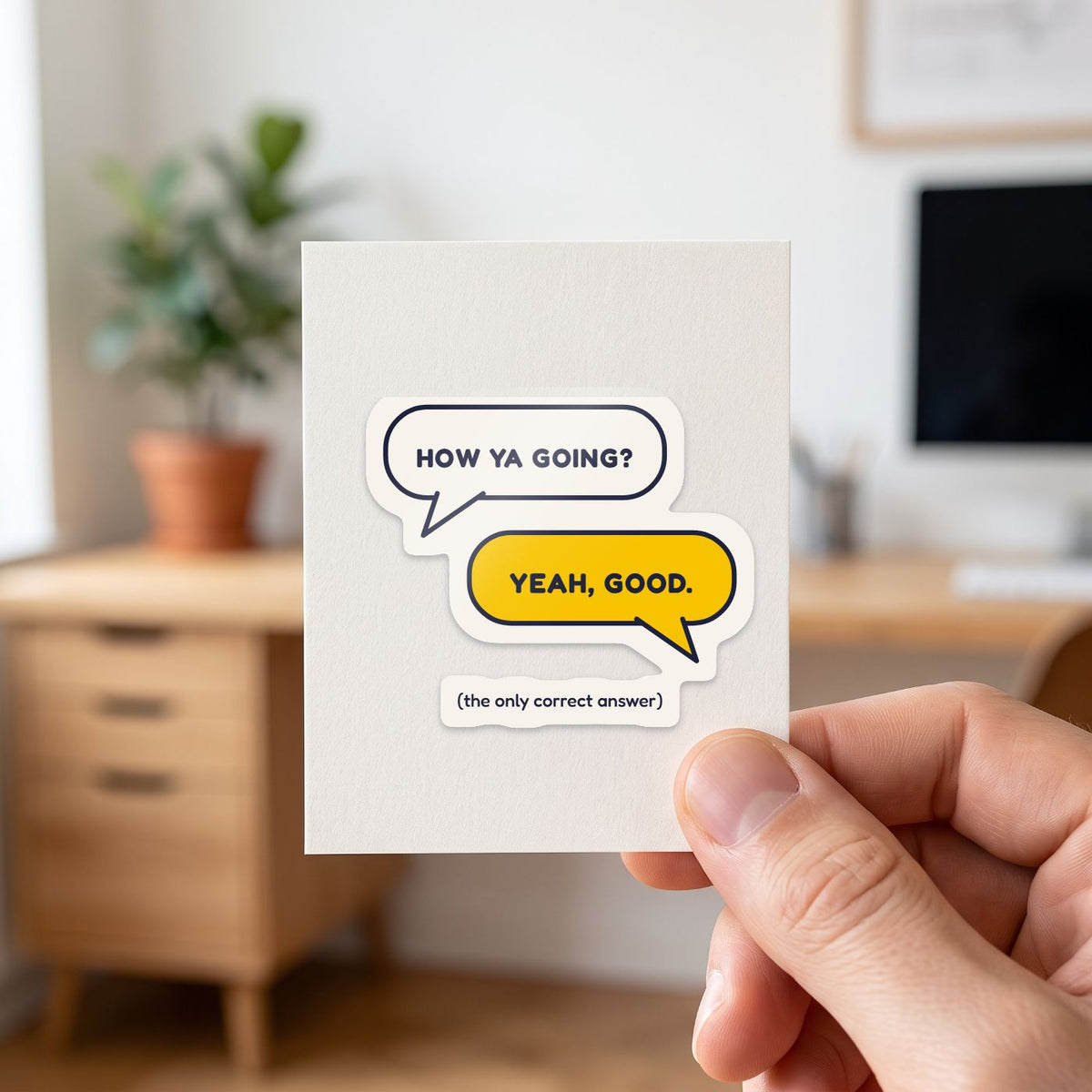 How Ya Going? Yeah, Good. sticker held in a hand on its white backing card
