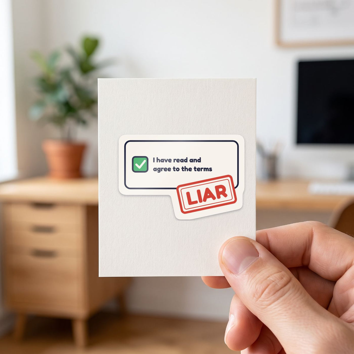 I Have Read the Terms sticker held in a hand on its white backing card