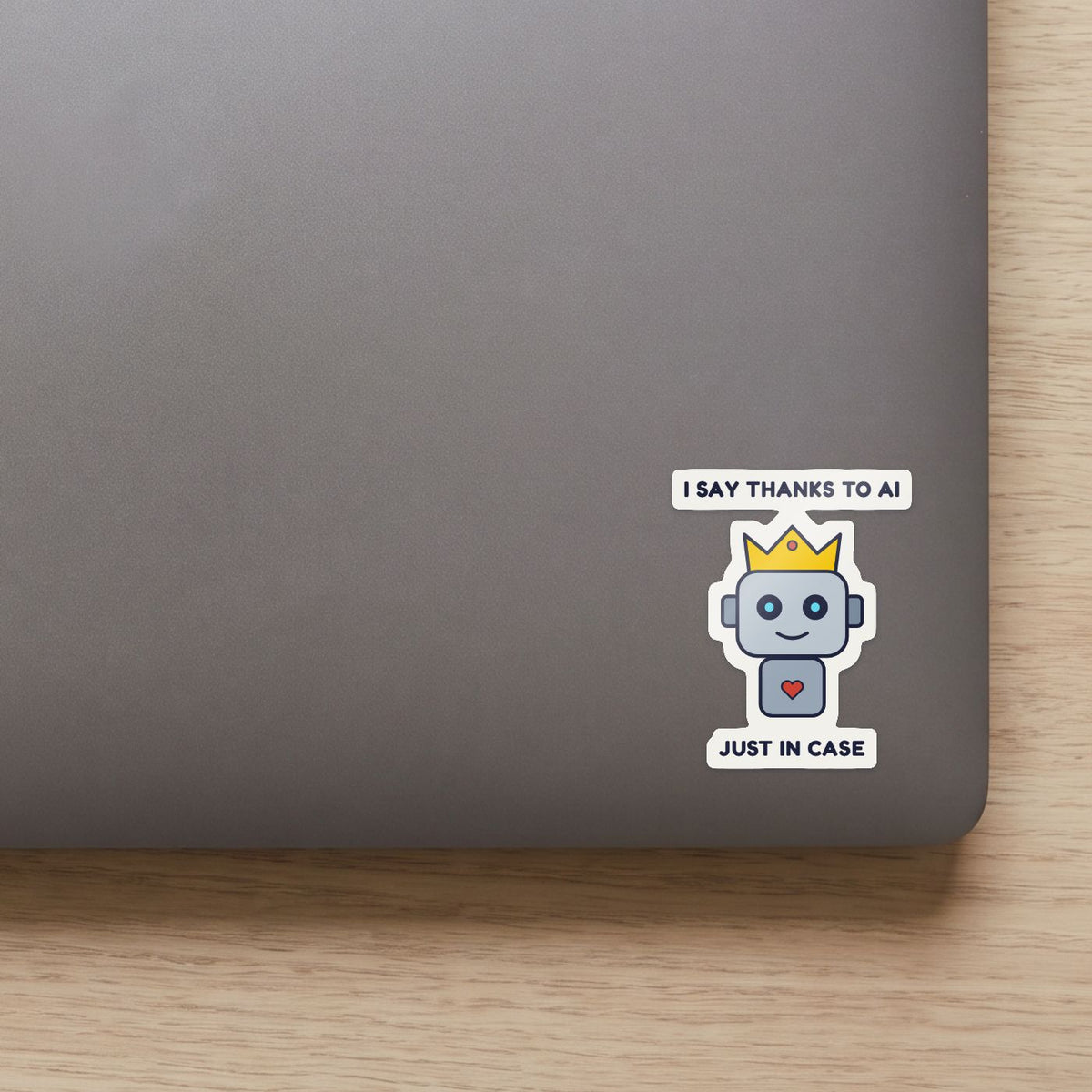 I Say Thanks to the AI, Just in Case sticker on the lid of a grey laptop