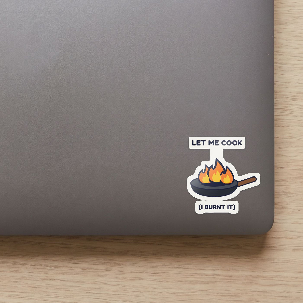 Let Me Cook sticker on the lid of a grey laptop