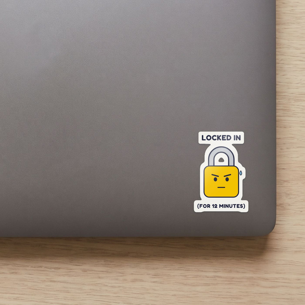 Locked In (for 12 Minutes) sticker on the lid of a grey laptop