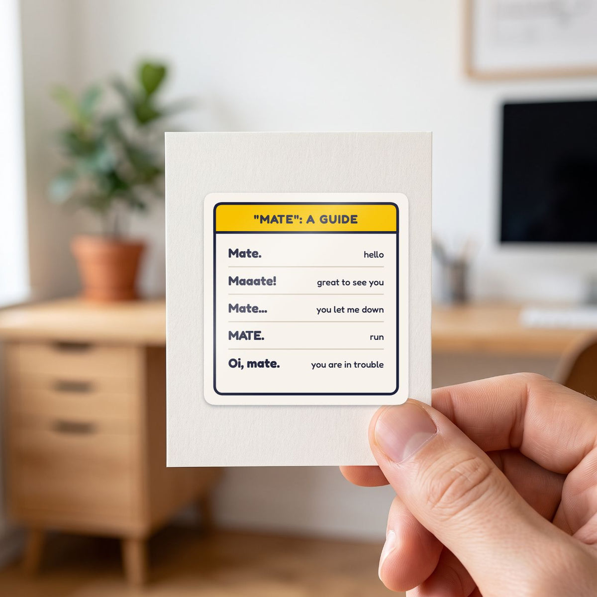 Mate: A Guide sticker held in a hand on its white backing card
