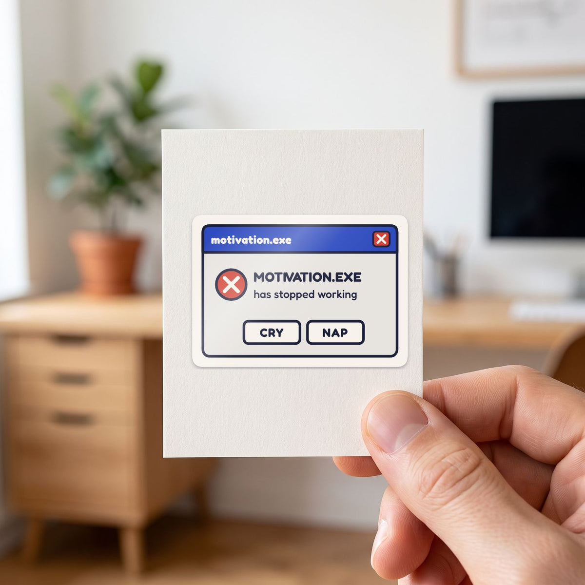 Motivation.exe Has Stopped Working sticker held in a hand on its white backing card