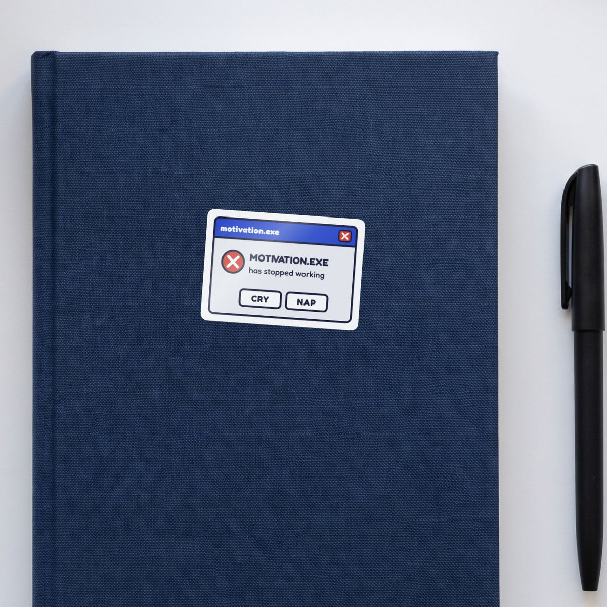 Motivation.exe Has Stopped Working sticker on a navy notebook