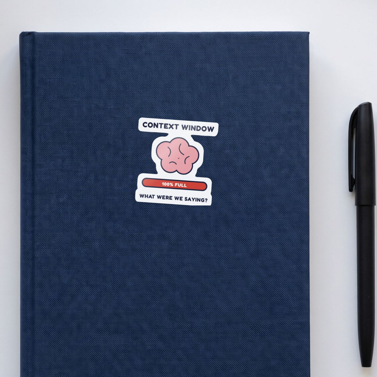 My Context Window Is Full sticker on a navy notebook