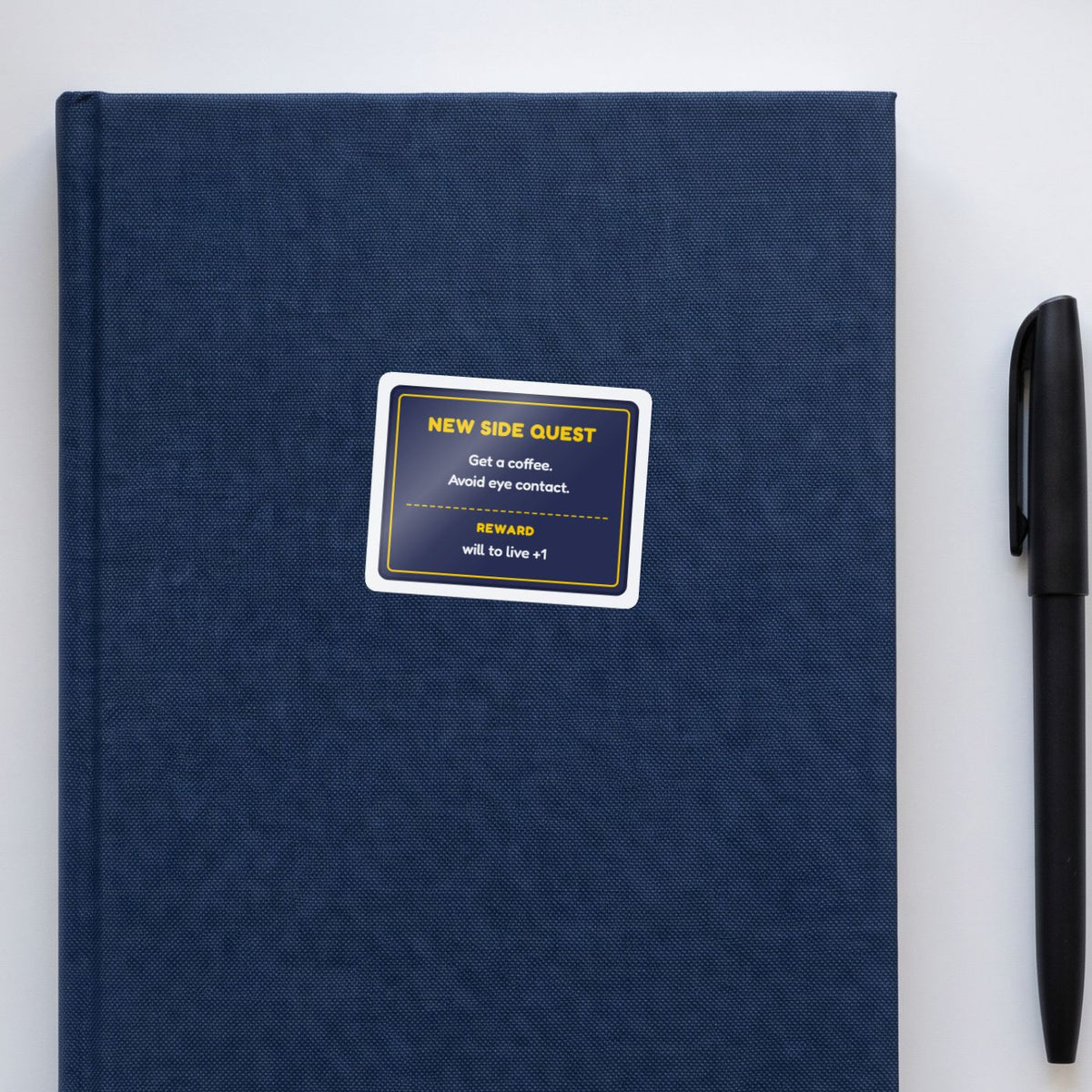 New Side Quest sticker on a navy notebook