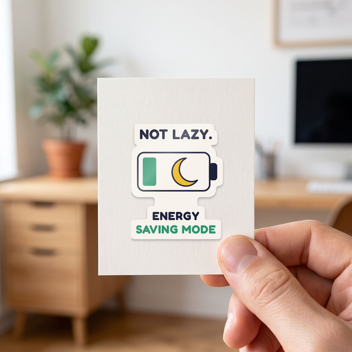 Not Lazy. Energy Saving Mode. sticker held in a hand on its white backing card