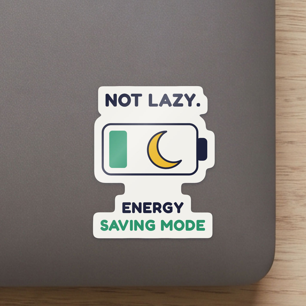 Not Lazy. Energy Saving Mode. sticker close up on a laptop lid, showing the gloss and the white cut edge