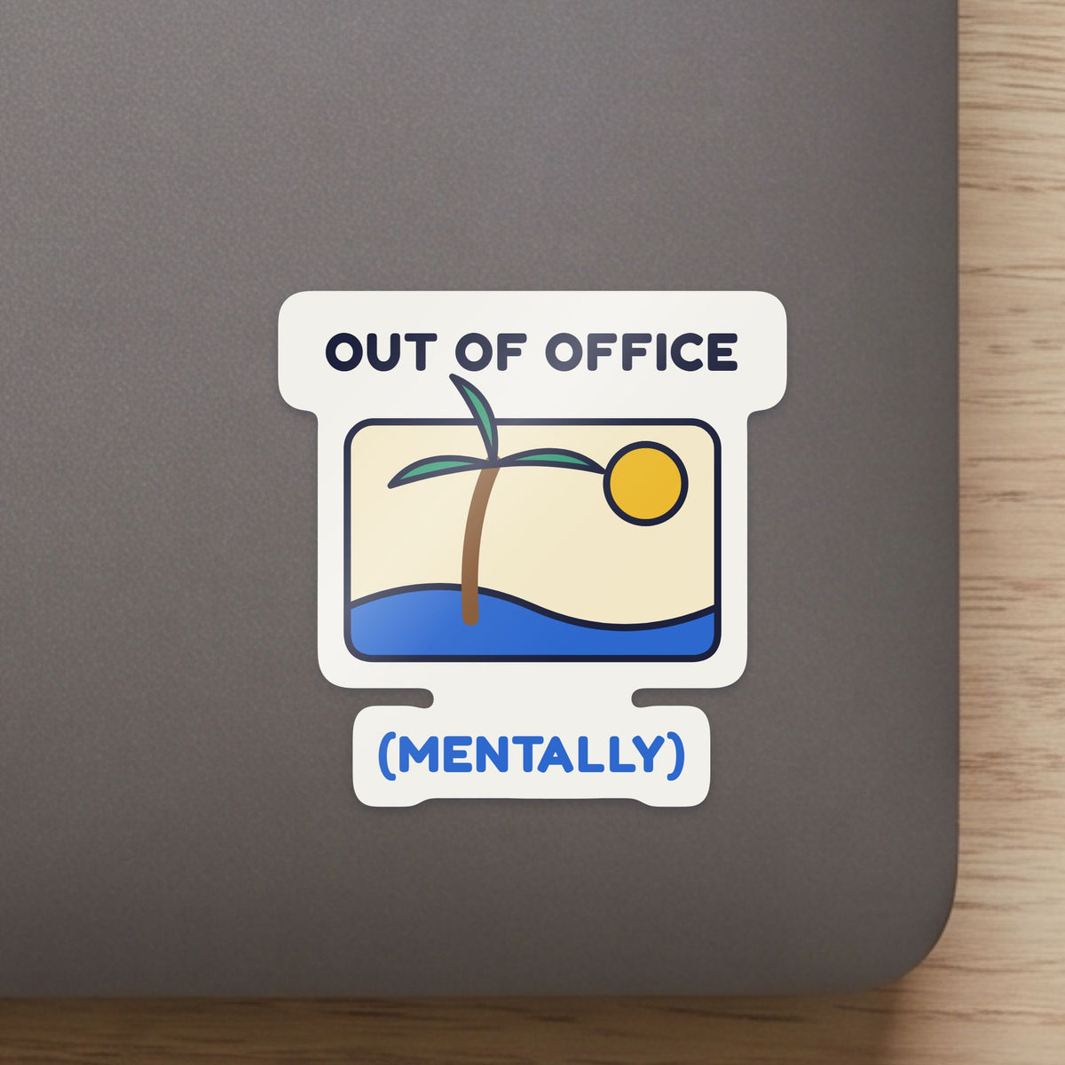 Out of Office (Mentally) sticker close up on a laptop lid, showing the gloss and the white cut edge