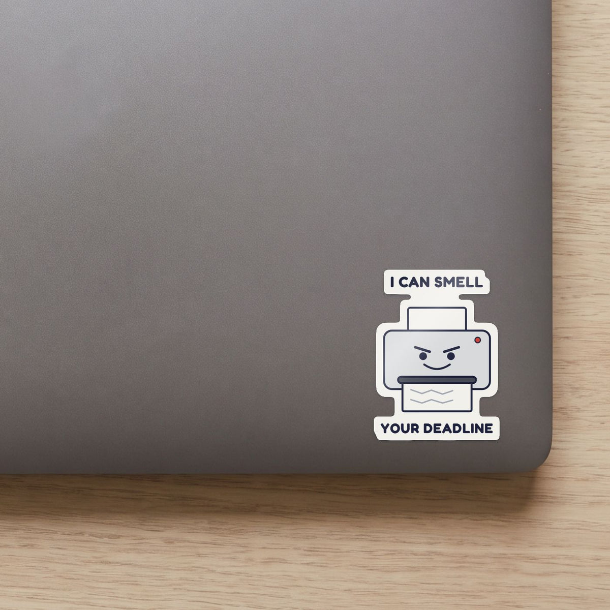 Printer: I Can Smell Your Deadline sticker on the lid of a grey laptop