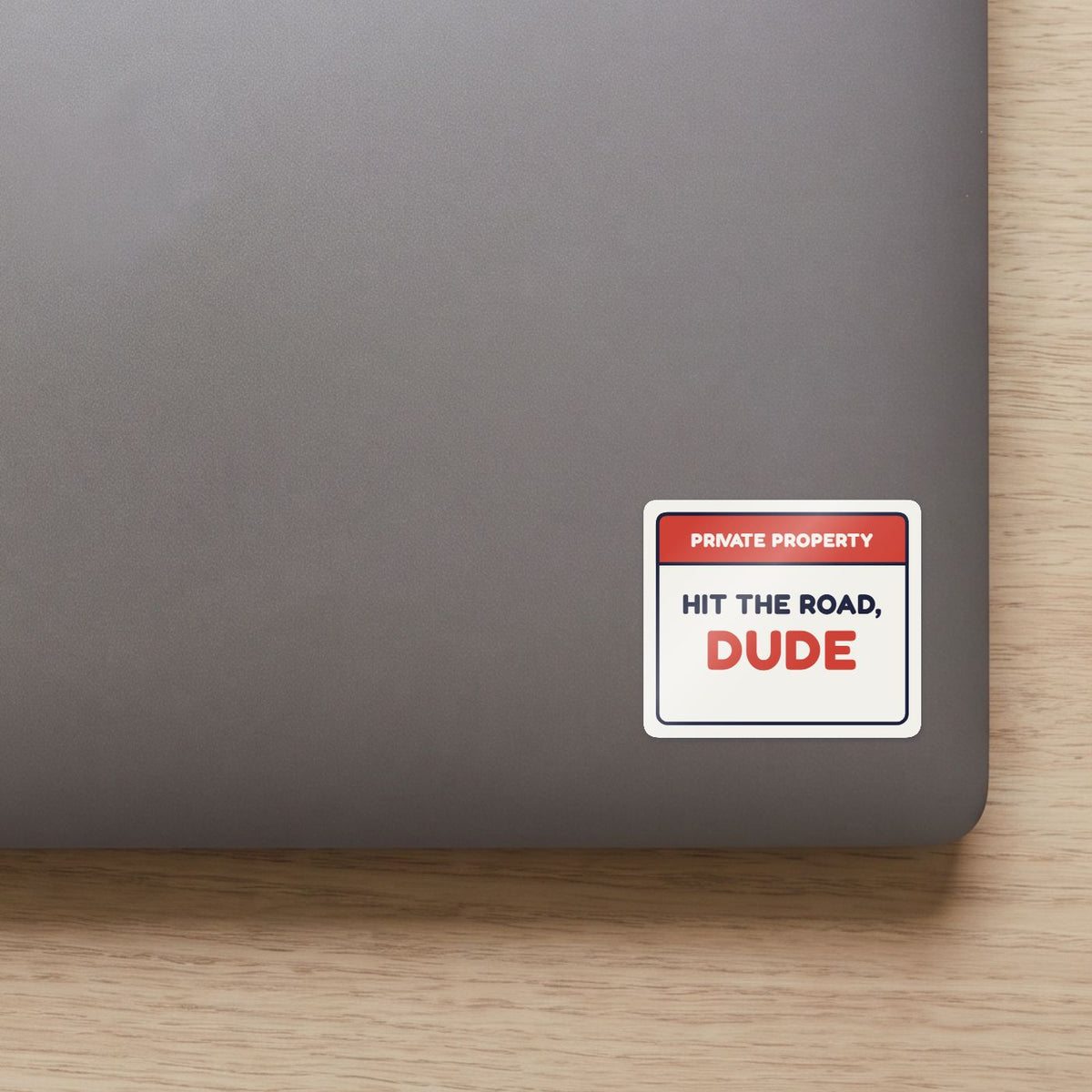 Private Property: Hit the Road, Dude sticker on the lid of a grey laptop