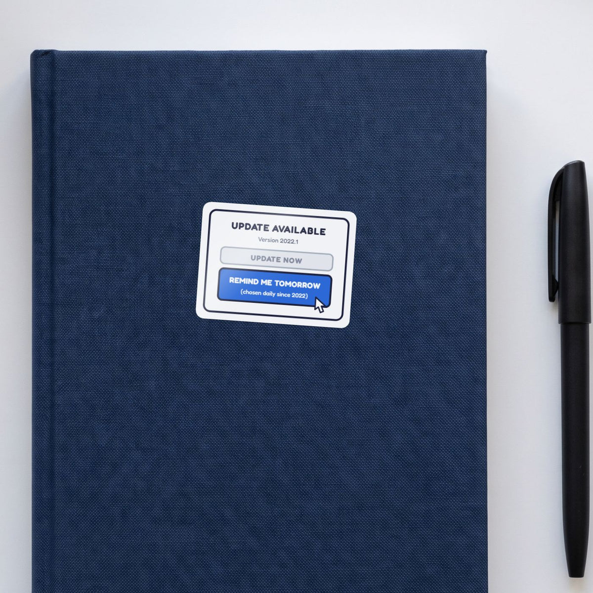 Remind Me Tomorrow sticker on a navy notebook