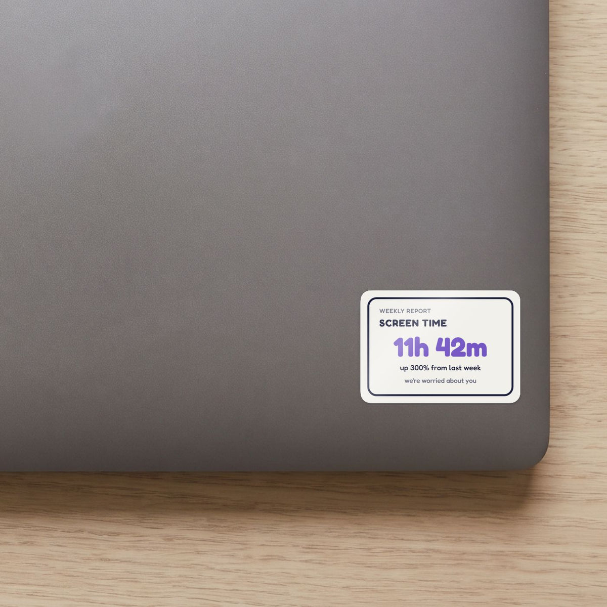 Screen Time: 11h 42m sticker on the lid of a grey laptop