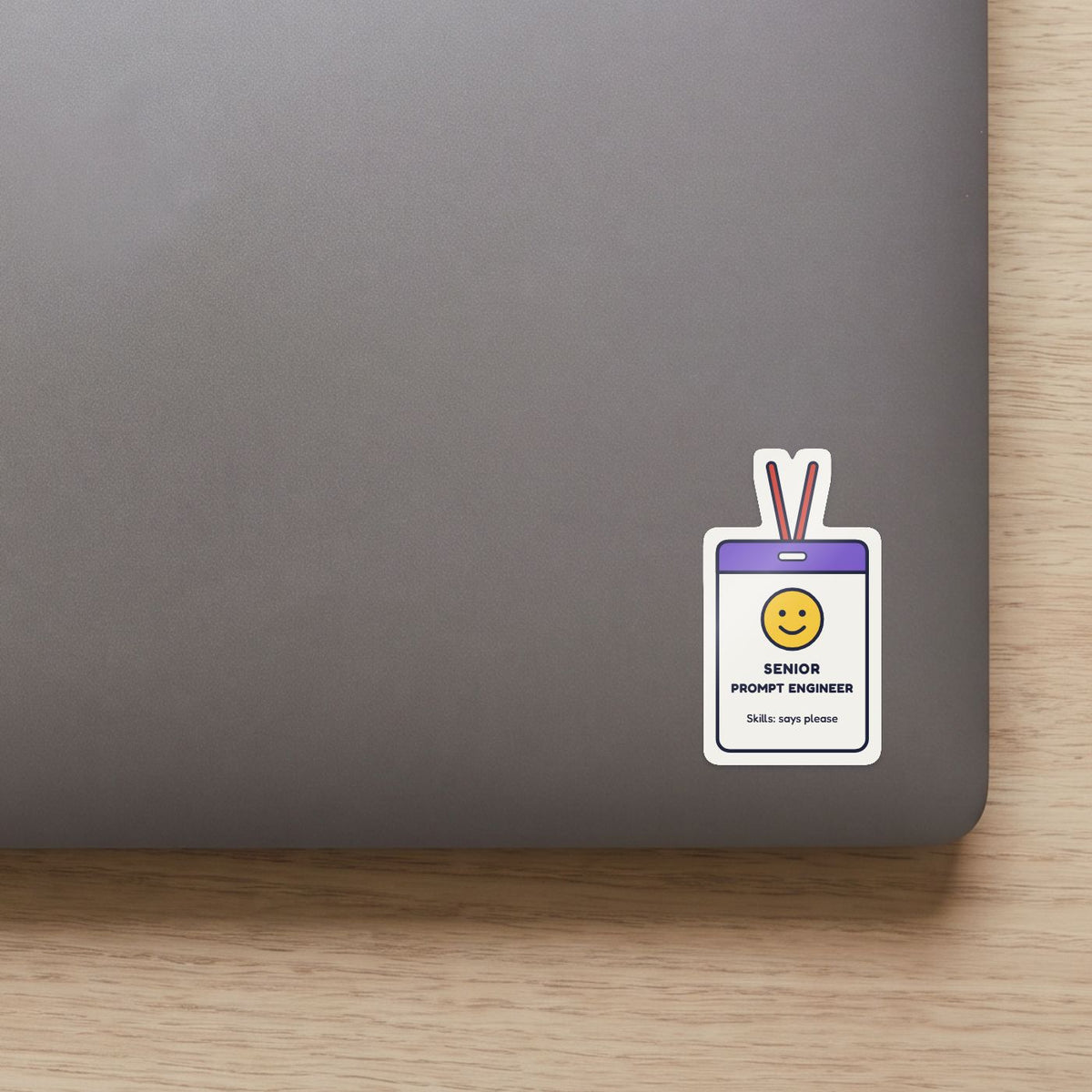 Senior Prompt Engineer sticker on the lid of a grey laptop
