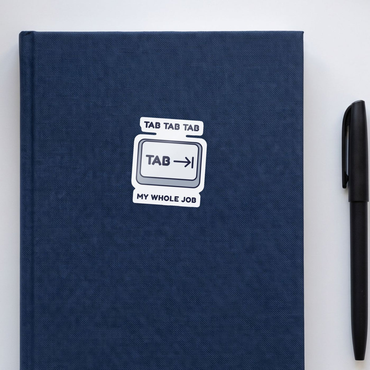 Tab Tab Tab sticker on a navy notebook