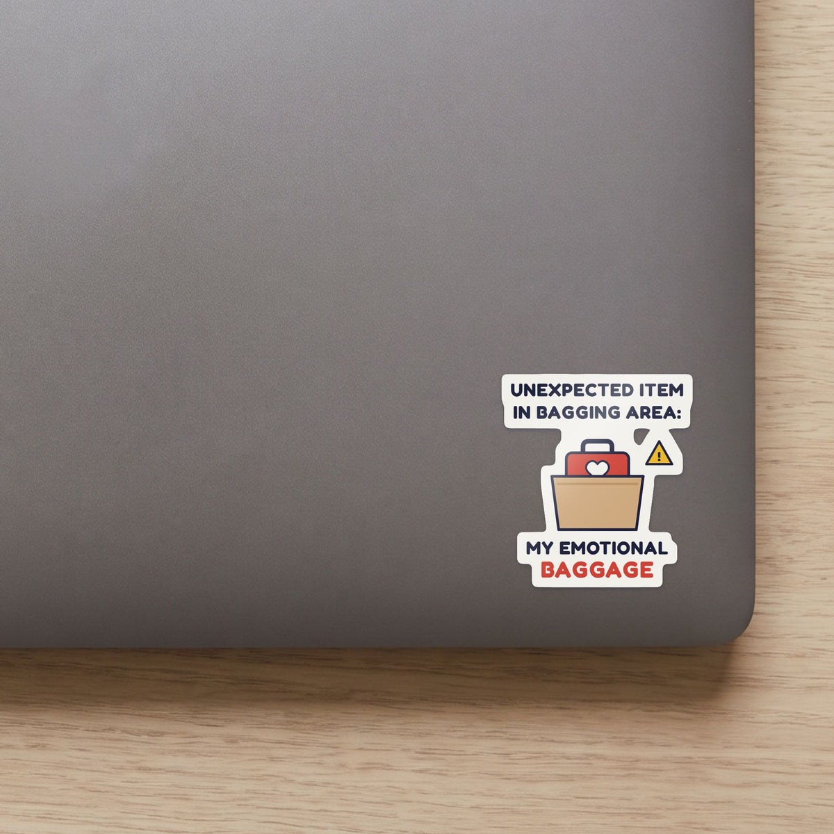 Unexpected Item in Bagging Area sticker on the lid of a grey laptop