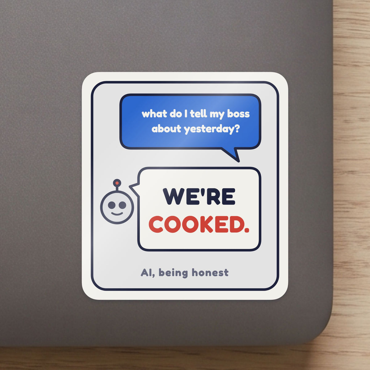 We're Cooked sticker close up on a laptop lid, showing the gloss and the white cut edge