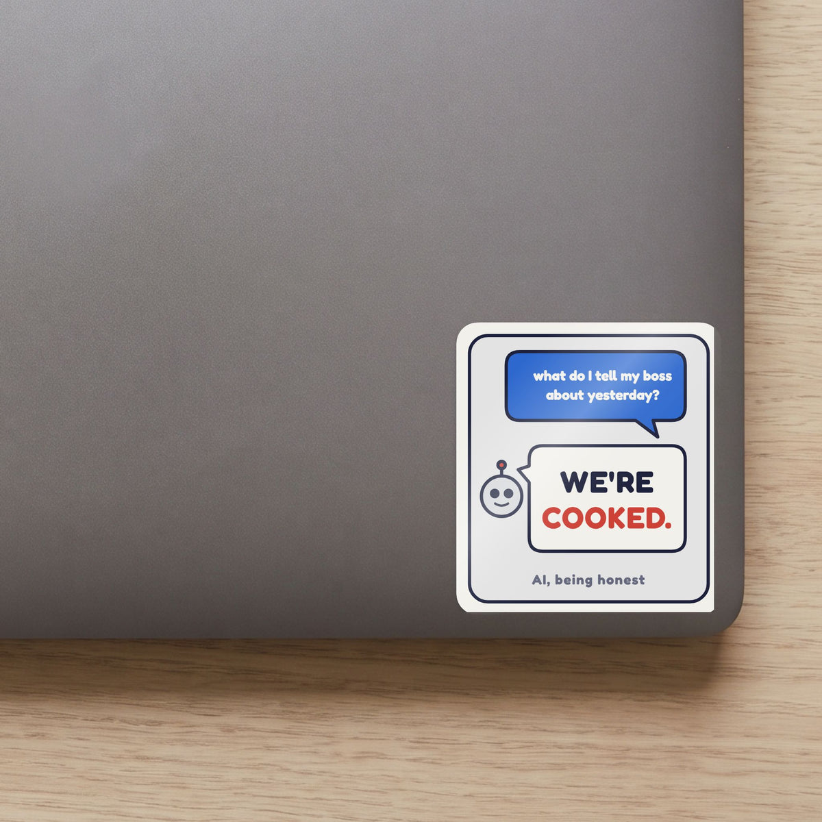 We're Cooked sticker on the lid of a grey laptop