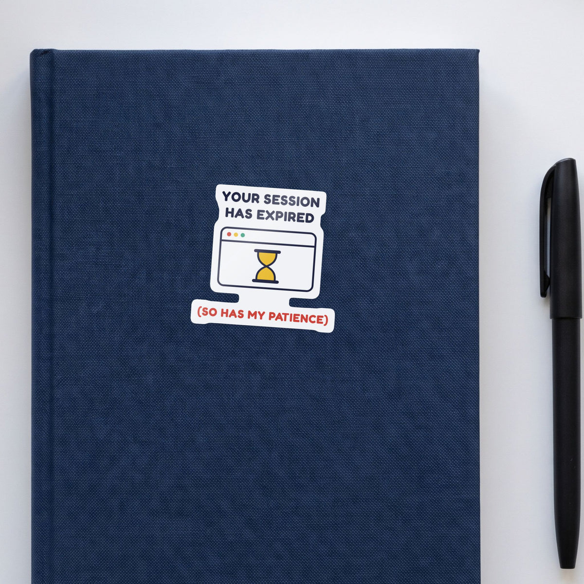 Your Session Has Expired sticker on a navy notebook