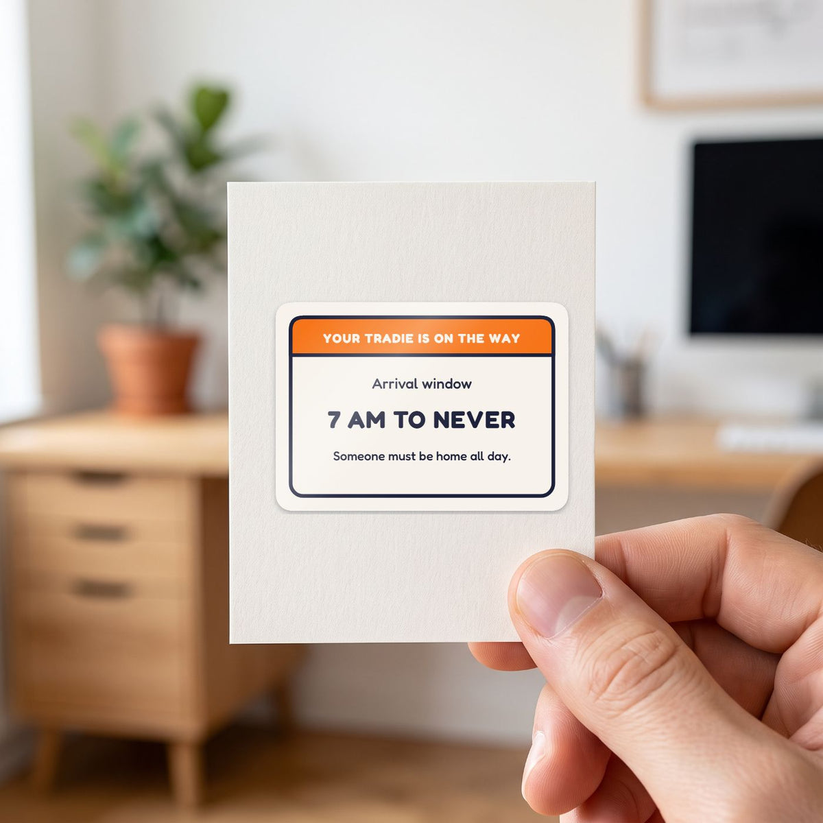Your Tradie: 7 am to Never sticker held in a hand on its white backing card